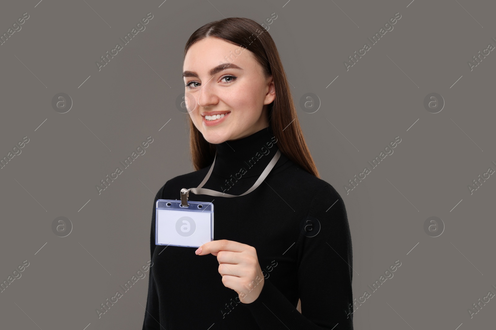 Photo of Happy woman with blank badge on grey background