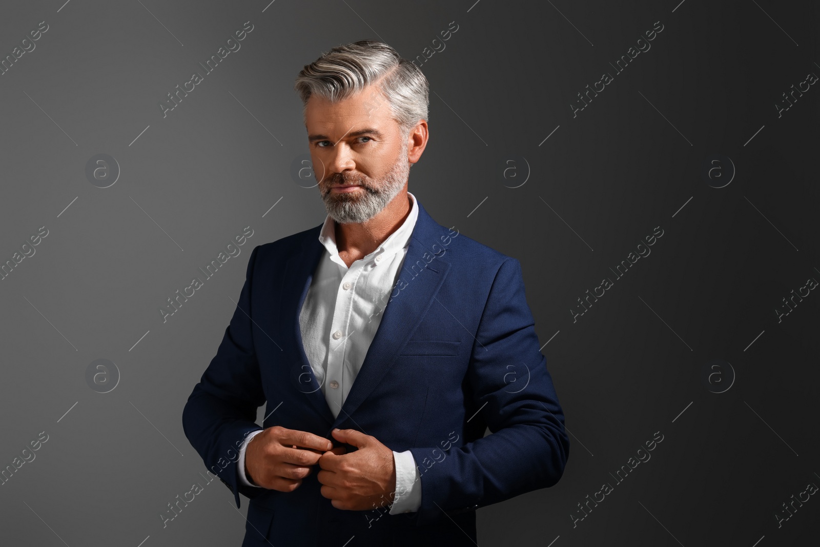 Photo of Portrait of confident man with beautiful hairstyle on dark background