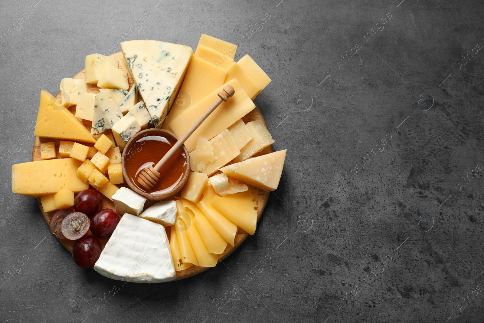 Photo of Different types of delicious cheese and snacks on served grey table, top view. Space for text