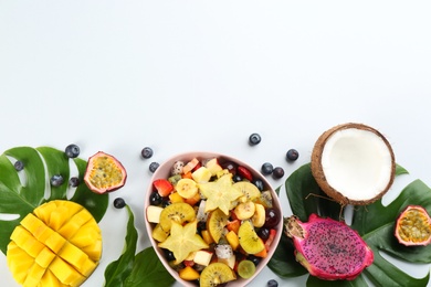 Composition with delicious exotic fruit salad on white background, top view