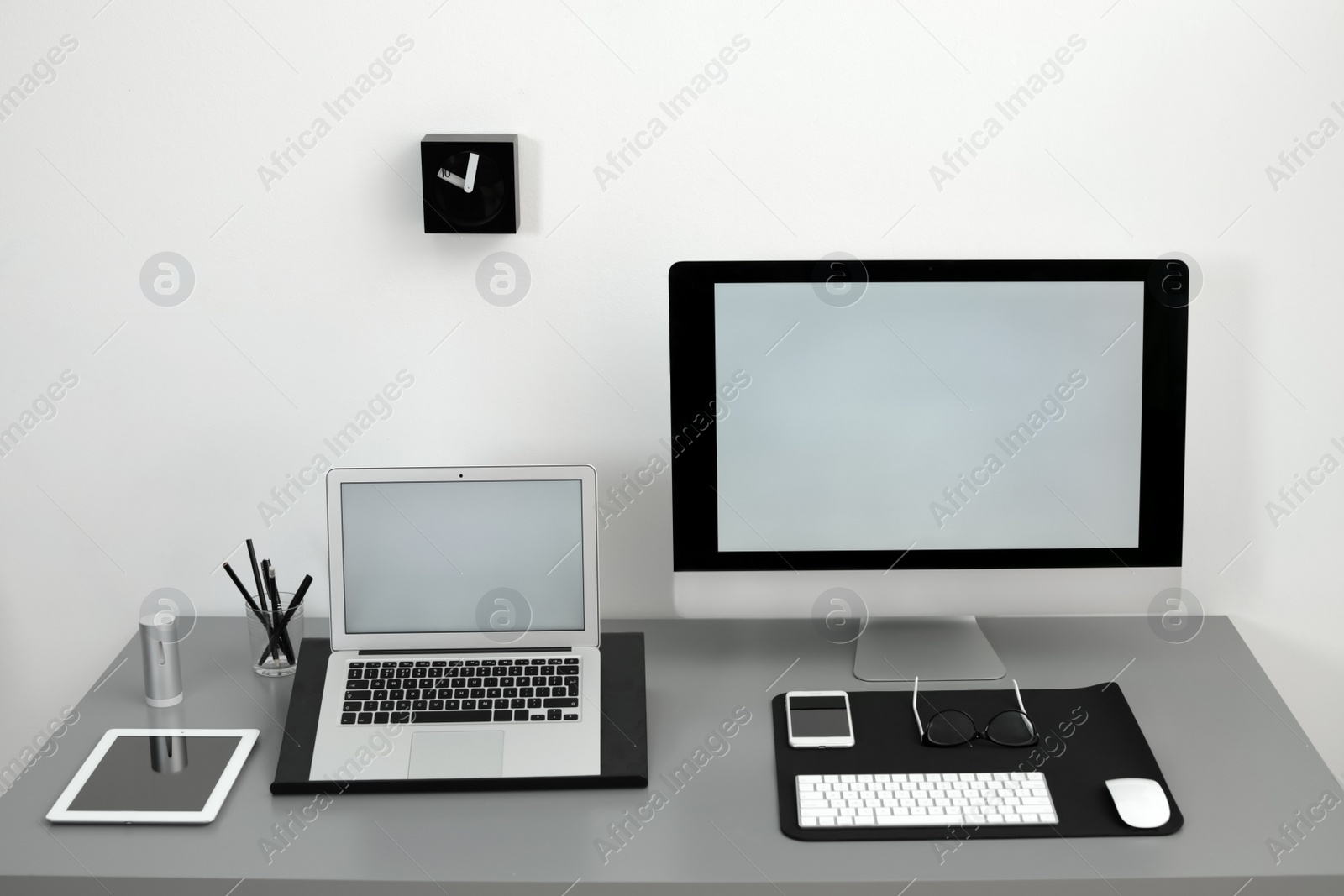 Photo of Modern workplace interior with computers on table. Space for text