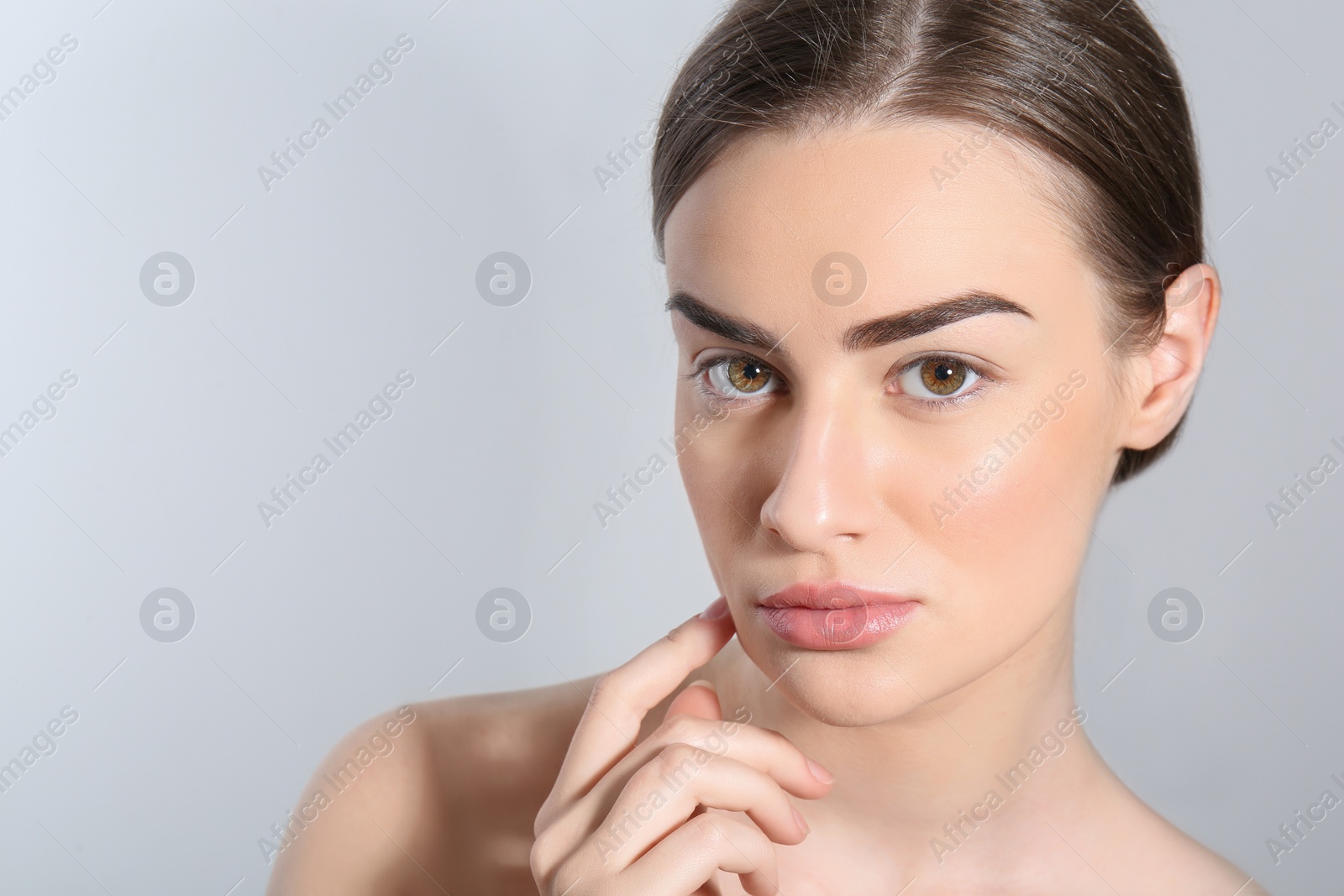 Photo of Beautiful woman with perfect eyebrows on light background