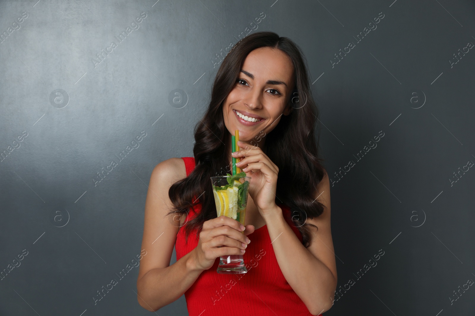 Photo of Young woman with refreshing drink on dark grey background