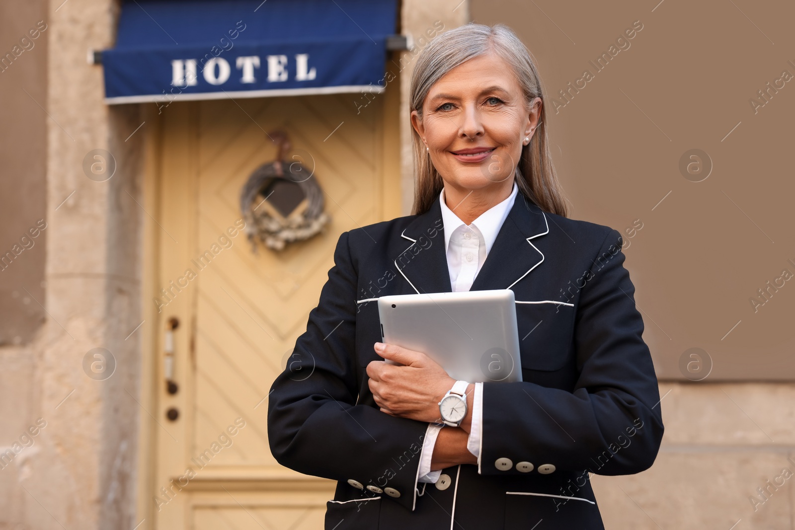 Photo of Smiling business owner with tablet near her hotel outdoors, space for text