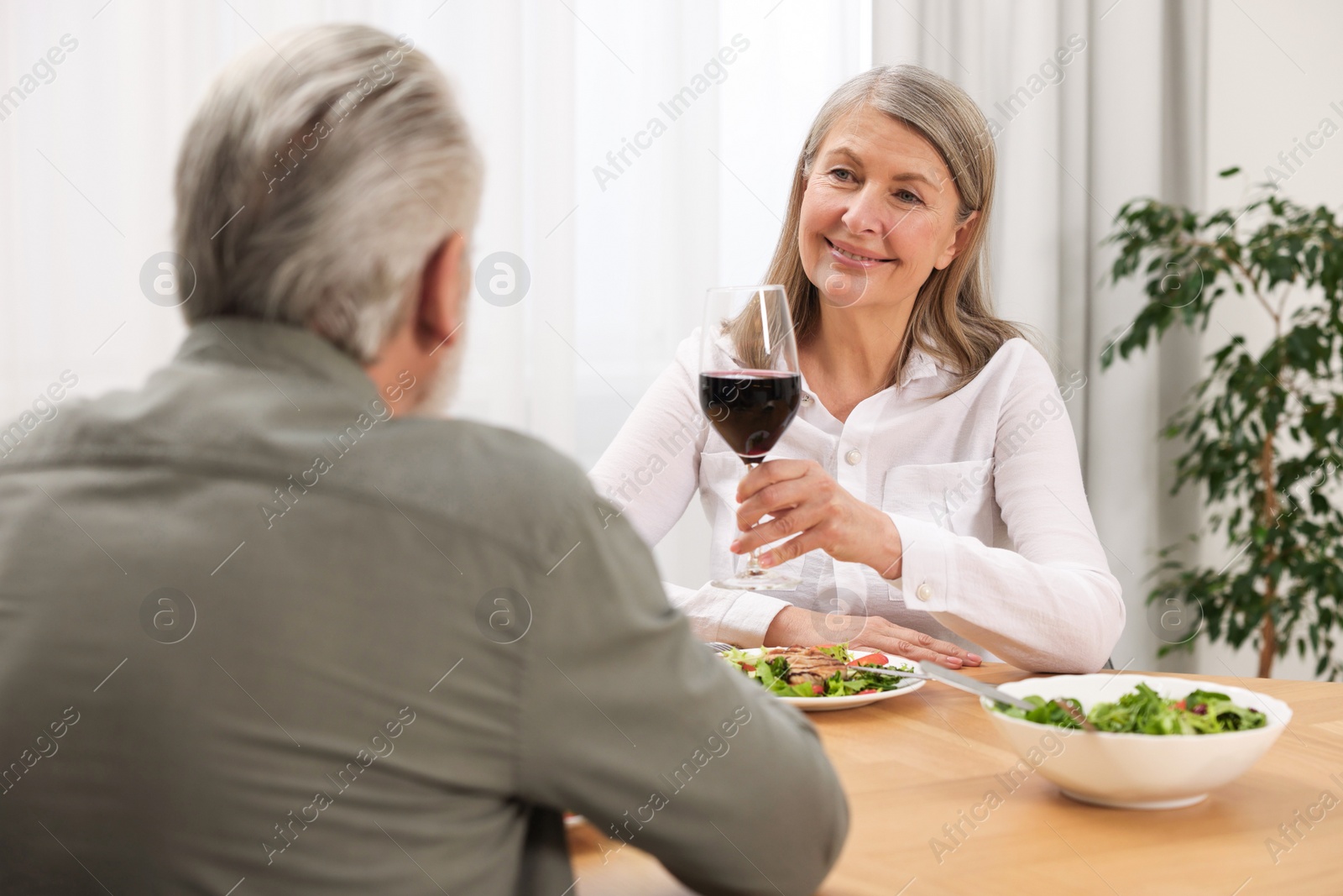 Photo of Happy senior couple having romantic dinner at home