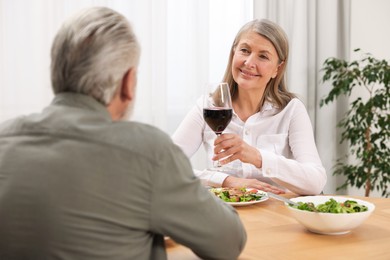 Happy senior couple having romantic dinner at home