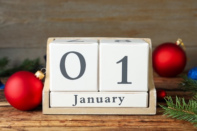 Wooden block calendar and Christmas decor on table. New Year celebration