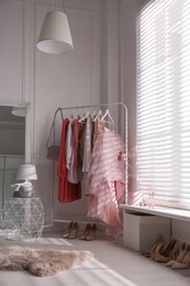 Modern dressing room interior with clothing rack near window