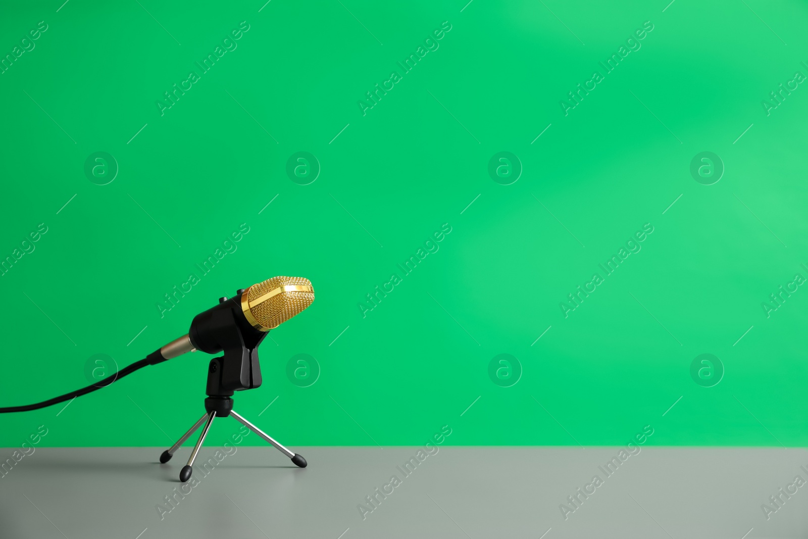 Photo of Microphone on table against green background, space for text. Journalist's work