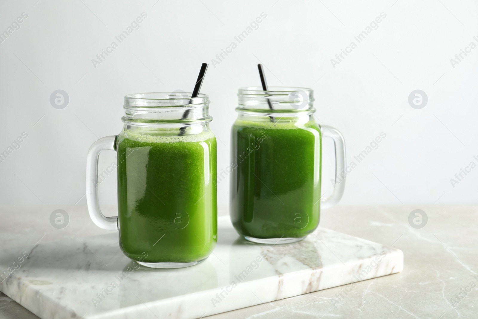 Photo of Mason jars with delicious detox juice on table