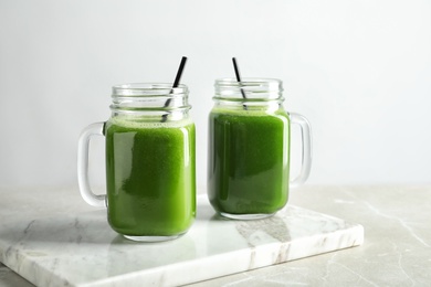 Mason jars with delicious detox juice on table