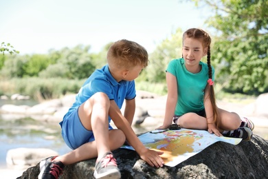 Photo of Little children with map outdoors. Summer camp