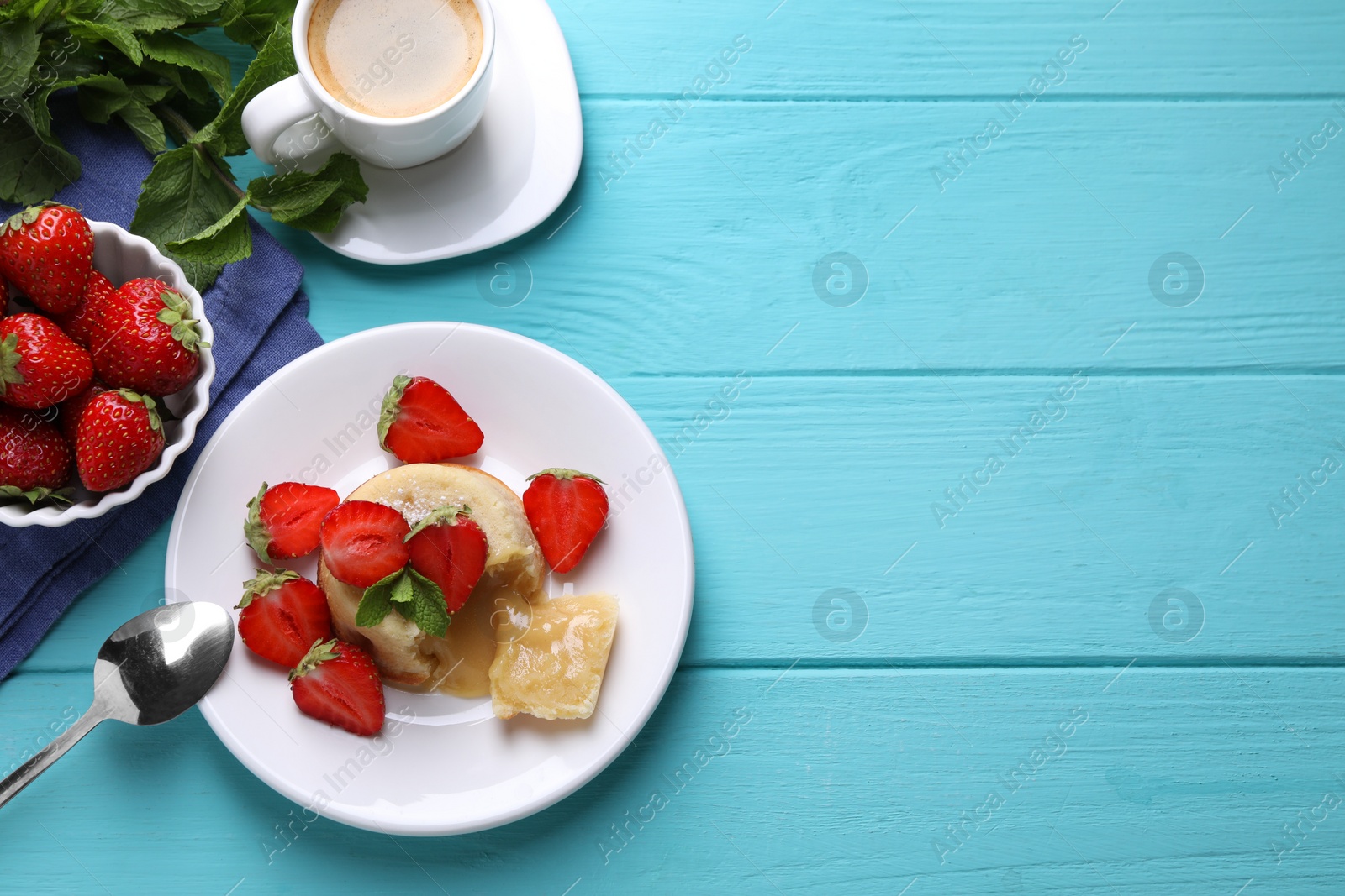 Photo of Tasty vanilla fondant with white chocolate, strawberries and cup of coffee on light blue wooden table, flat lay. Space for text