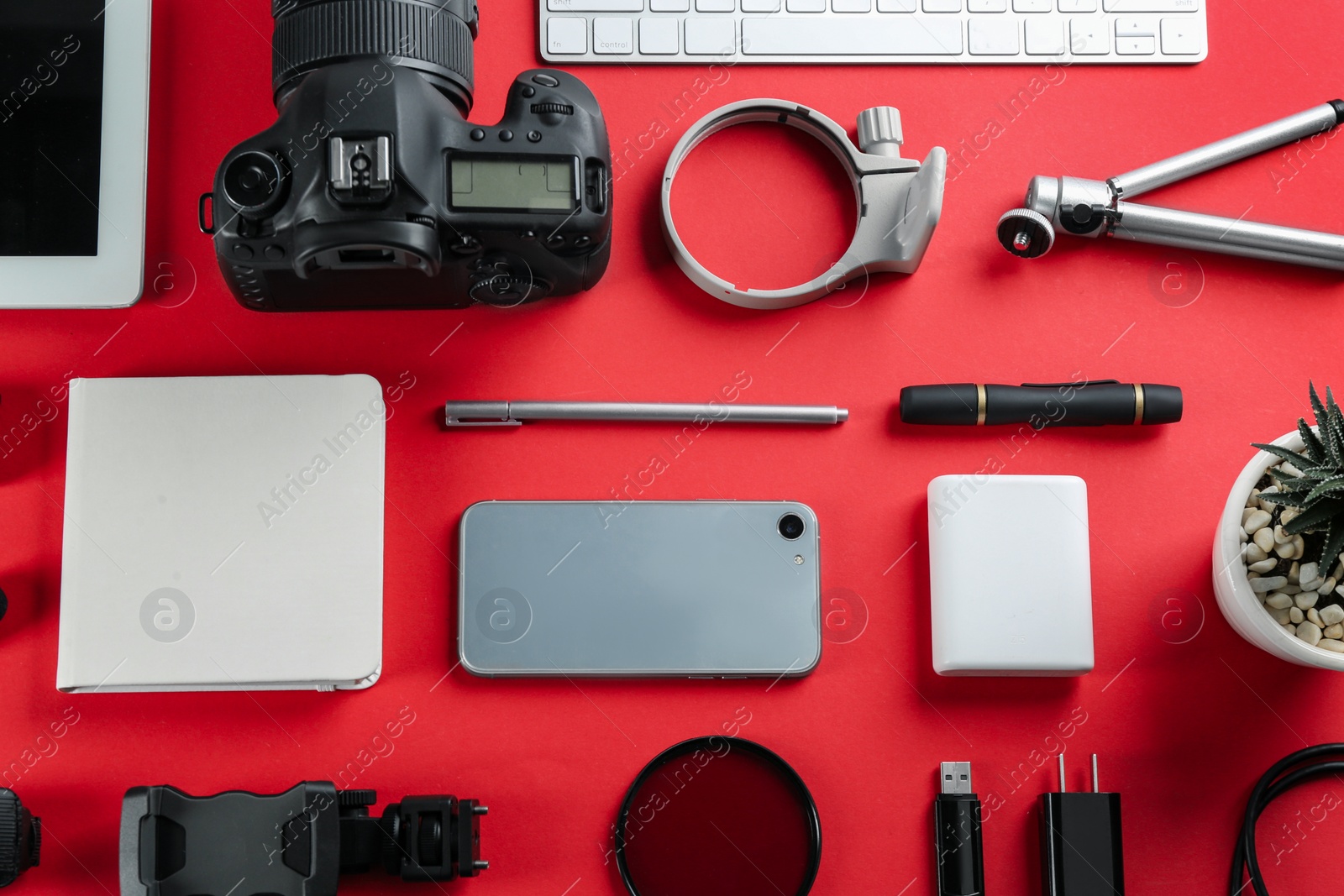 Photo of Flat lay composition with camera and video production equipment on red background