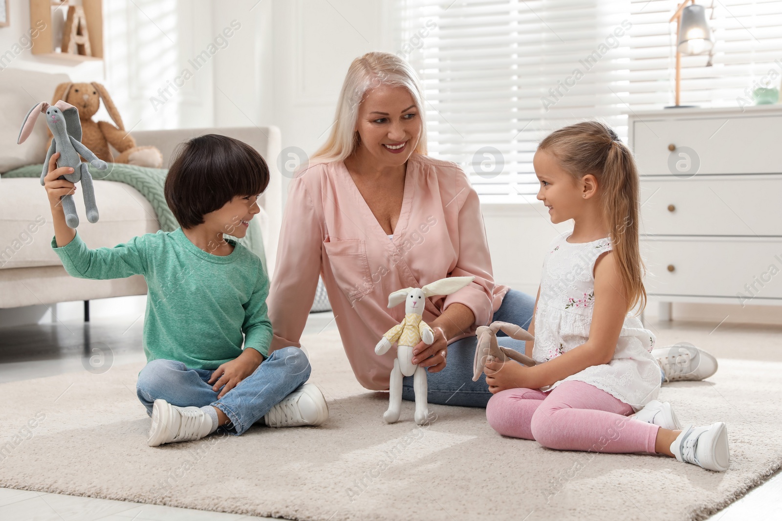 Photo of Happy grandmother and her grandchildren spending time together at home