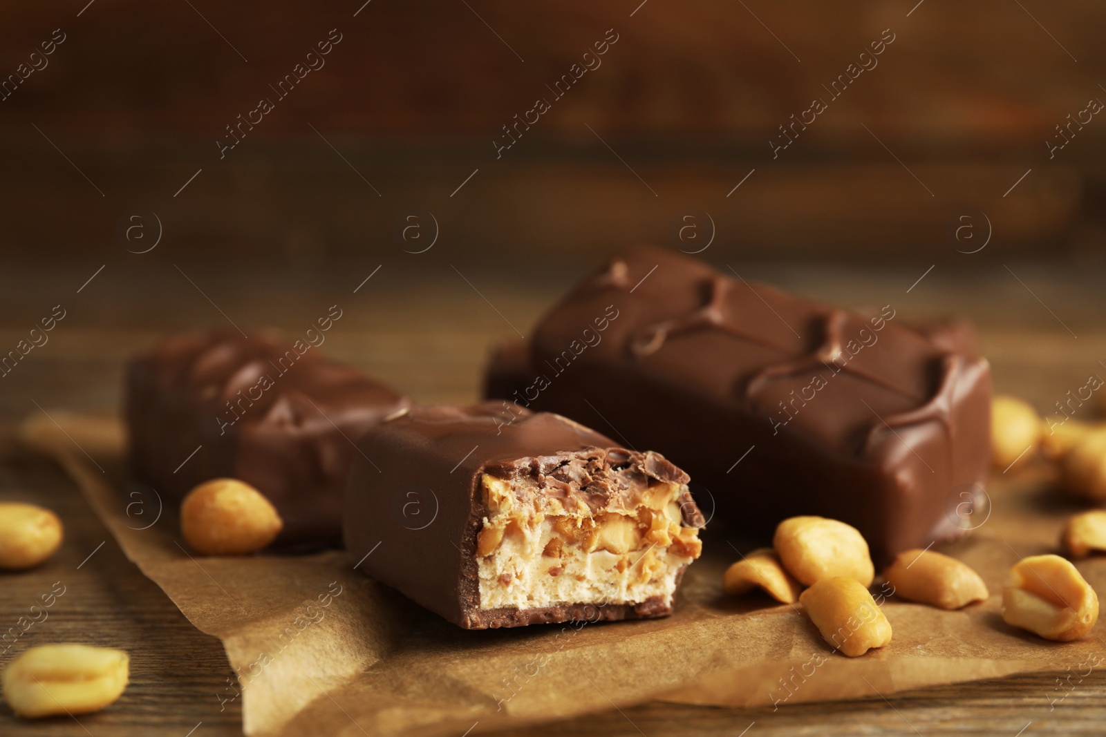 Photo of Chocolate bars with caramel, nuts and nougat on table, closeup