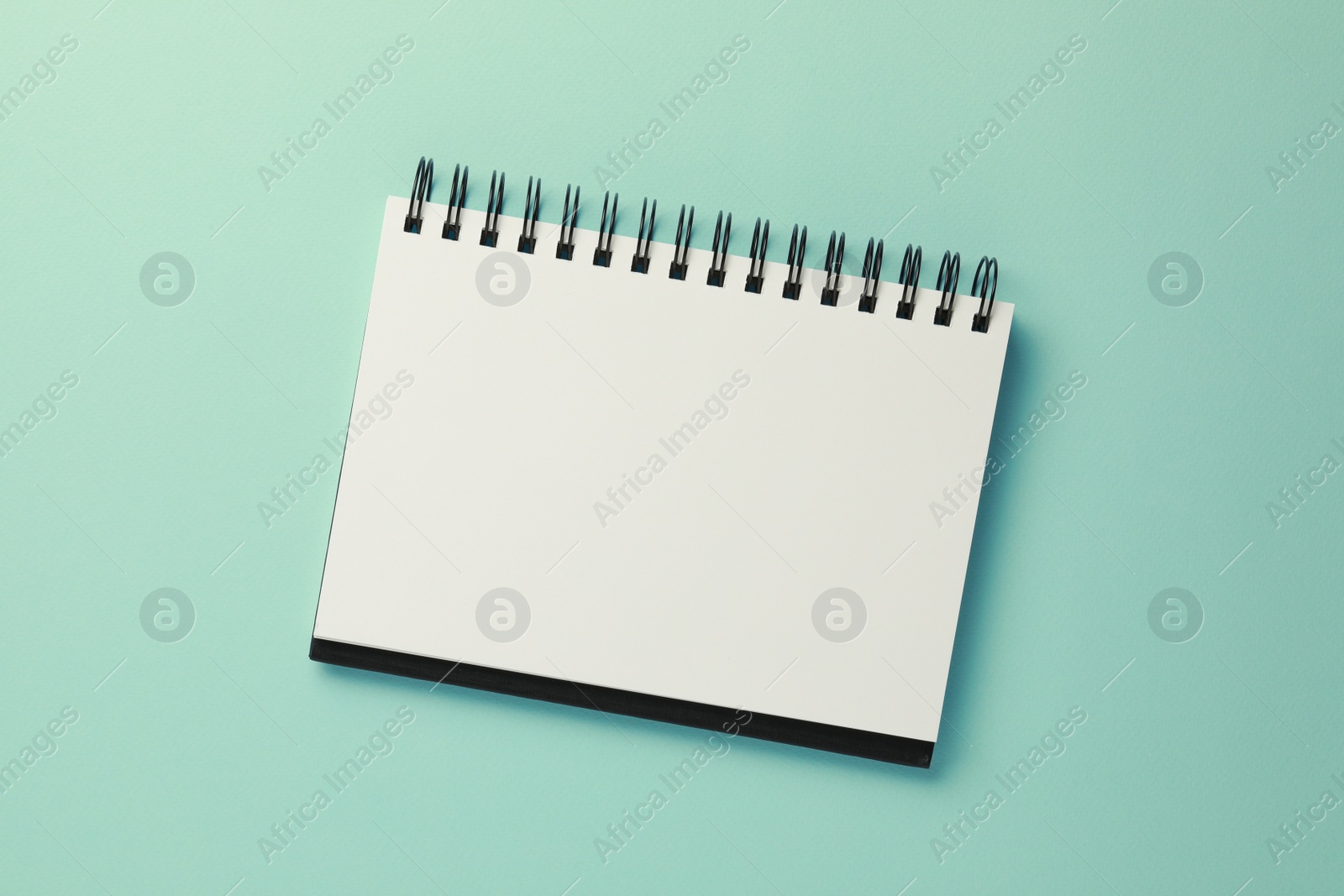 Photo of Blank notebook on turquoise background, top view