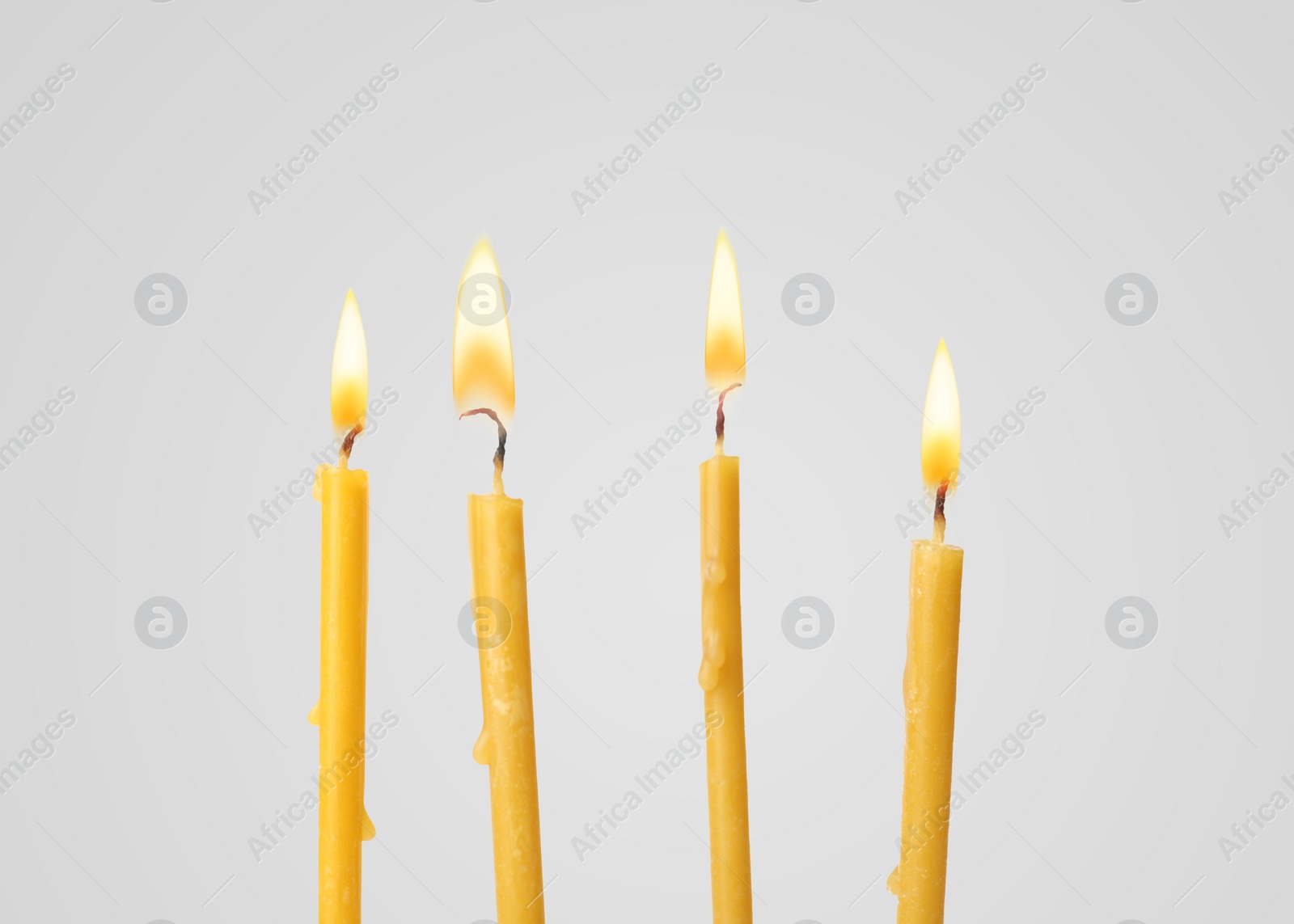 Image of Many burning church candles on light background