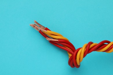 Photo of Electrical wires on light blue background, closeup