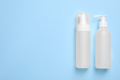 Photo of Different cleansers on light blue background, flat lay with space for text. Cosmetic product
