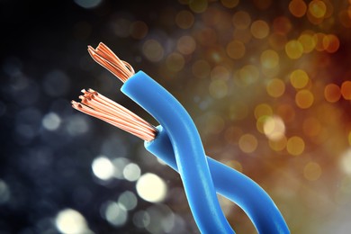 Image of Electrical wires against dark background with blurred lights, closeup. Bokeh effect