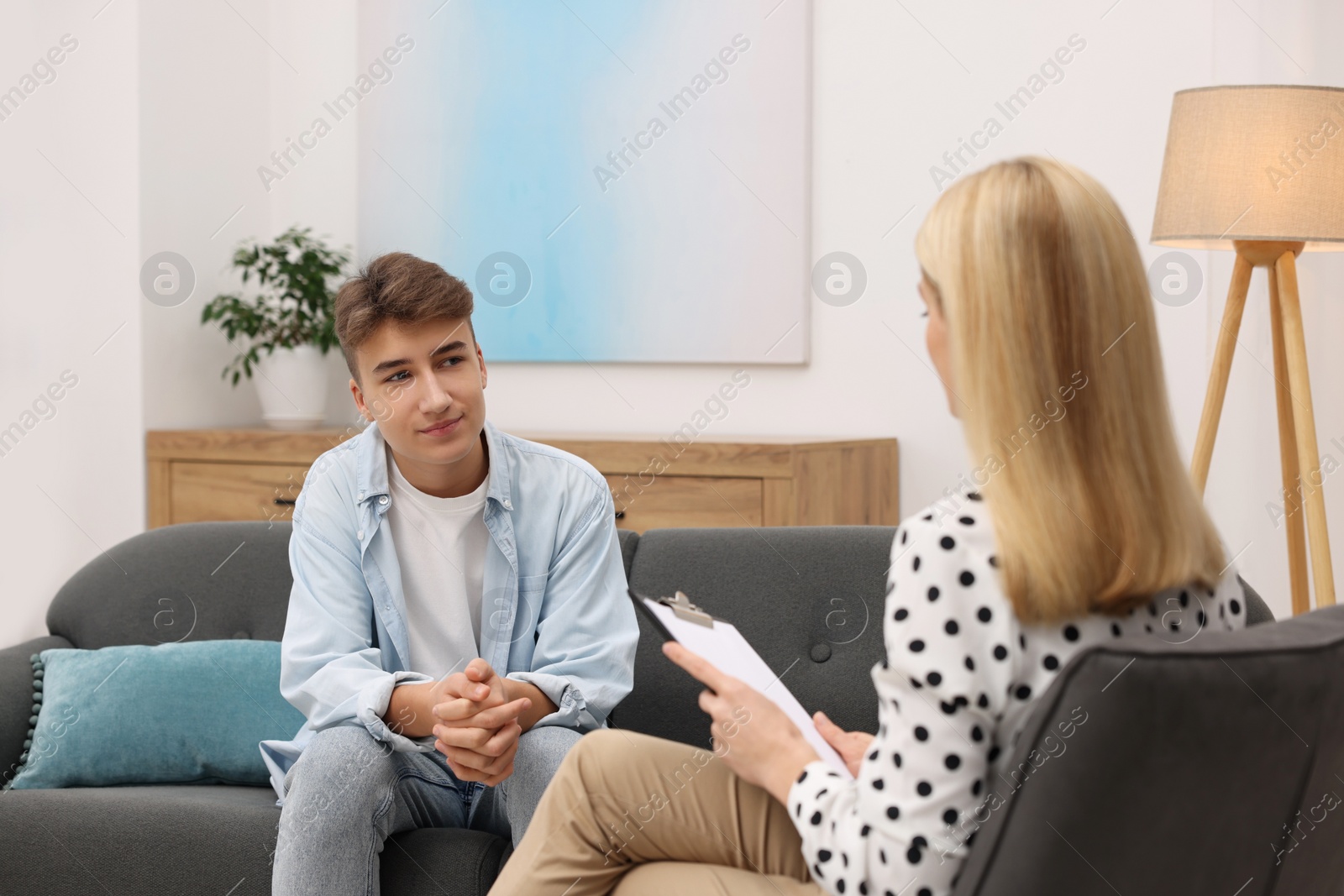 Photo of Psychologist working with teenage boy in office