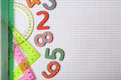 Photo of Flat lay composition with colorful numbers on sheet of grid paper. Space for text