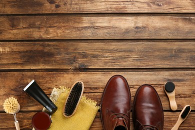 Photo of Flat lay composition with shoe care accessories and footwear on wooden background. Space for text