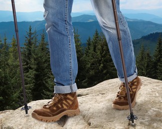 Image of Man with trekking poles in mountains on sunny day, closeup