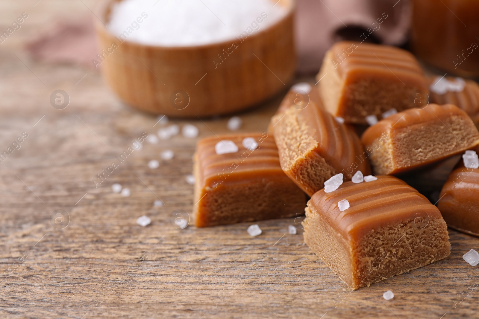 Photo of Delicious salted caramel on wooden table, closeup