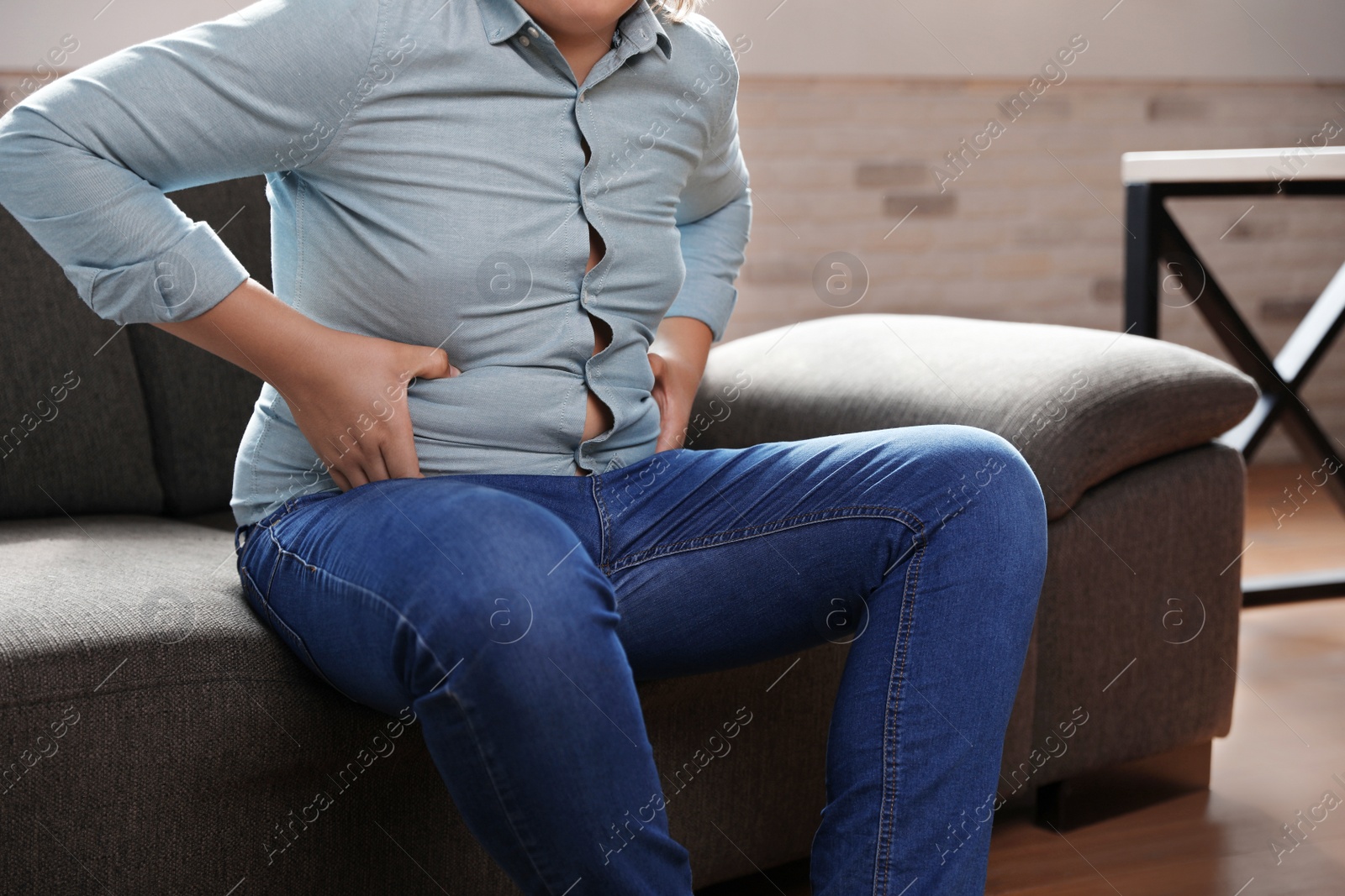Photo of Overweight boy sitting on sofa at home, closeup view