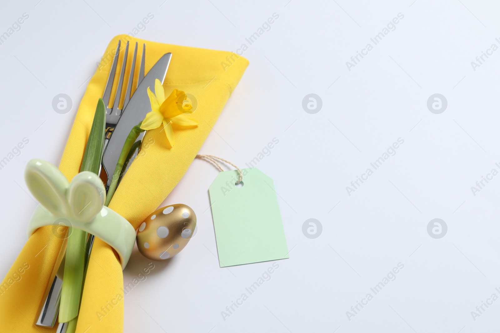 Photo of Cutlery set, Easter egg and narcissus on white background, space for text. Festive table setting