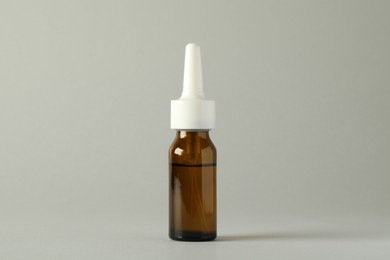 Photo of Bottle of nasal spray on light grey background