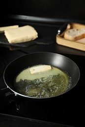 Melting butter in frying pan on cooktop