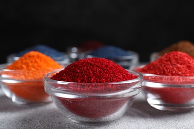 Photo of Different food coloring on light grey table, closeup