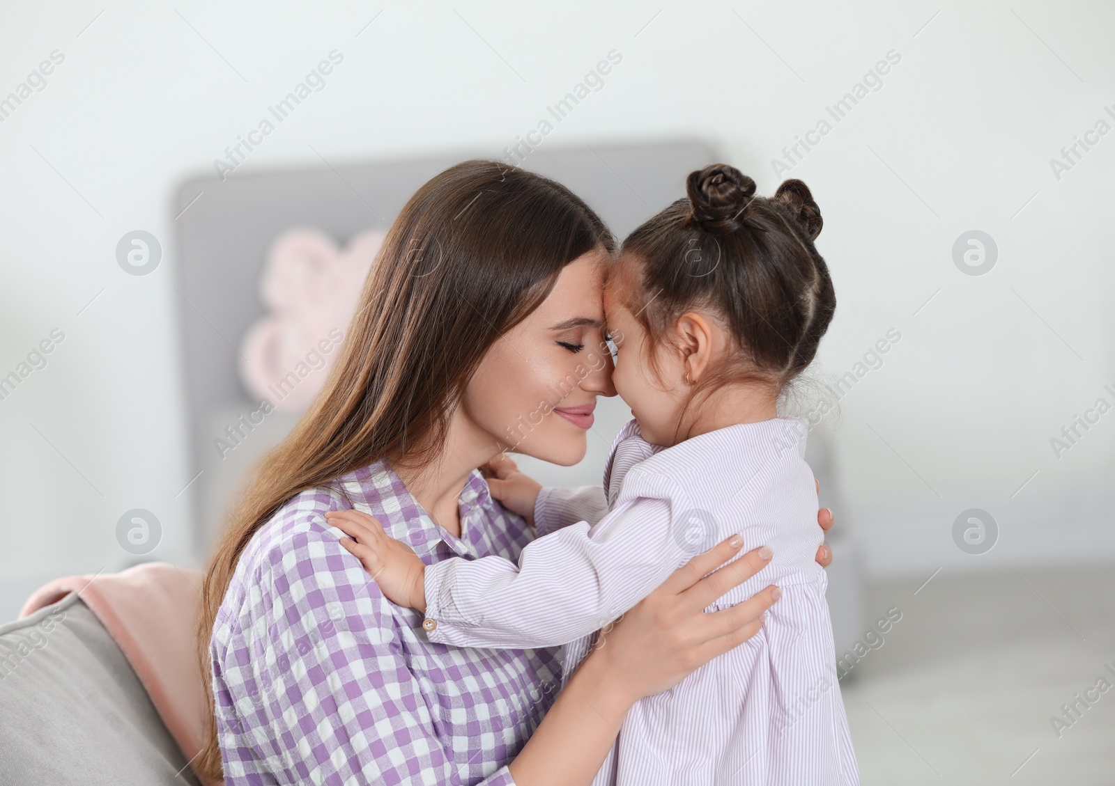 Photo of Young mother with little daughter at home