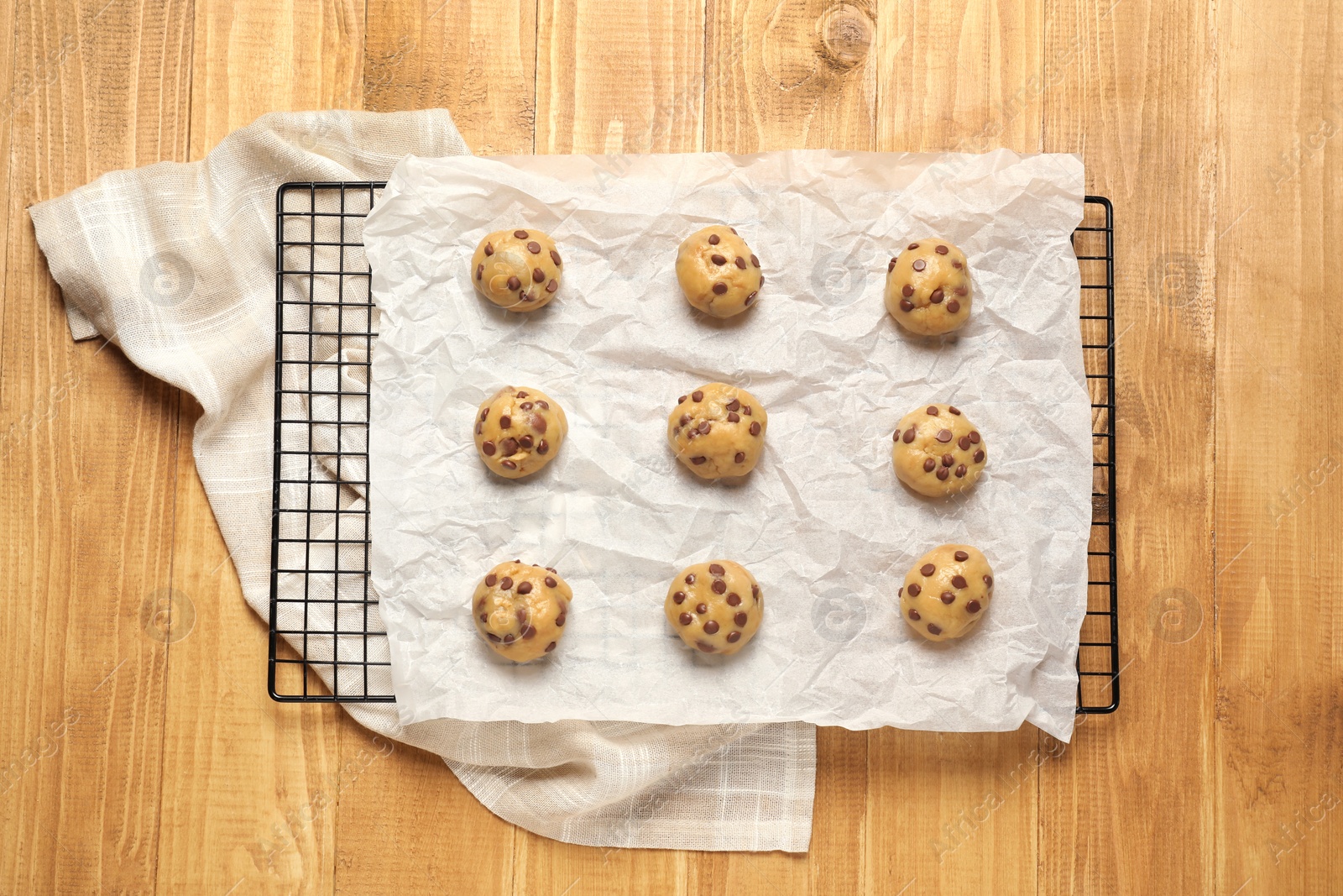 Photo of Uncooked chocolate chip cookies on wooden table, top view