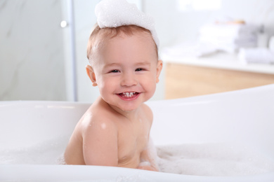 Photo of Cute little baby in bathtub at home