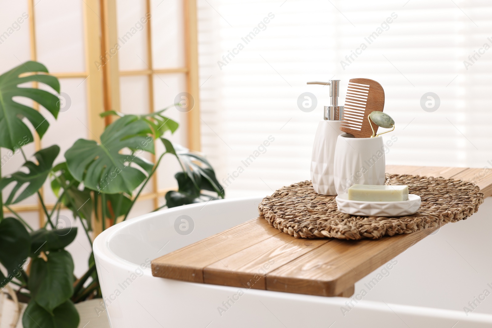 Photo of Different personal care products and accessories on bath tub in bathroom