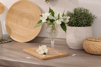 Photo of Beautiful jasmine flowers on wooden table indoors