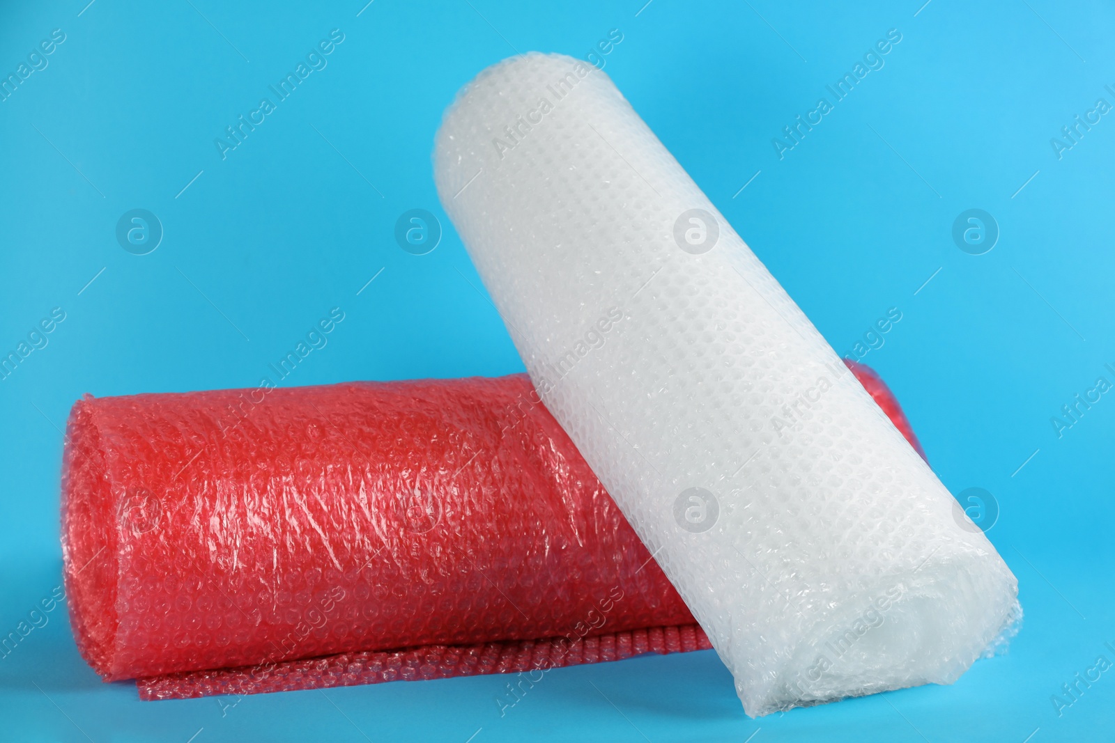 Photo of Bubble wrap rolls on light blue background