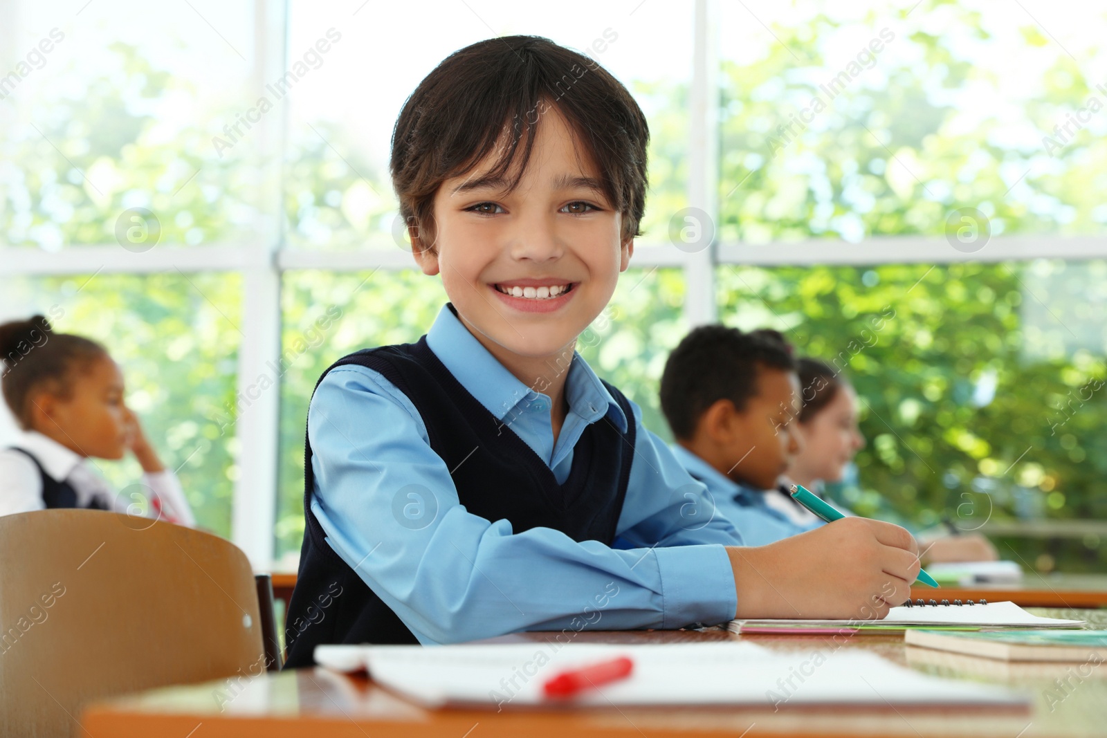 Photo of Boy wearing new school uniform in classroom