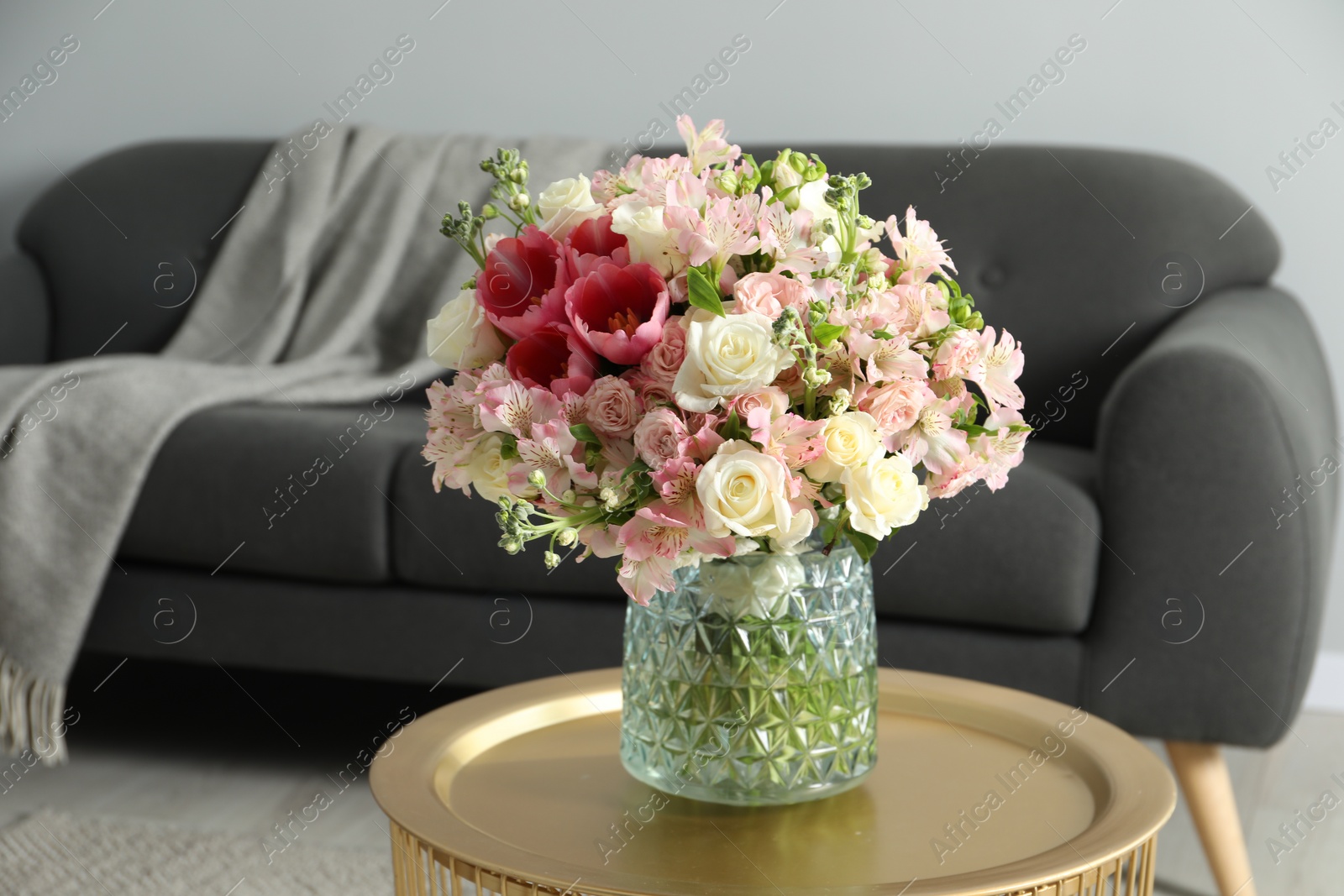 Photo of Beautiful bouquet of fresh flowers on coffee table in room