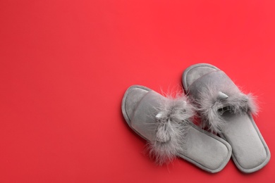 Photo of Pair of stylish soft slippers on red background, flat lay. Space for text