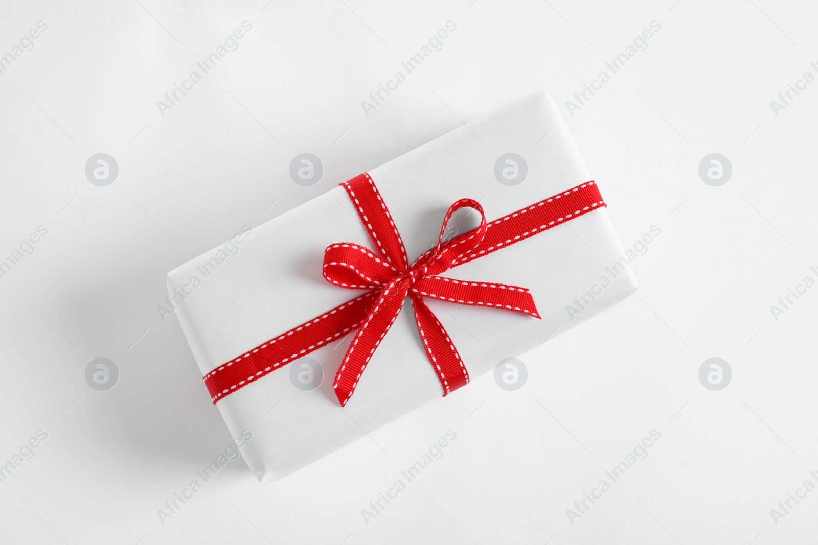 Photo of Beautifully wrapped gift box on white background, top view