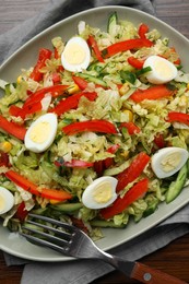 Photo of Delicious salad with Chinese cabbage and quail eggs served on wooden table, top view