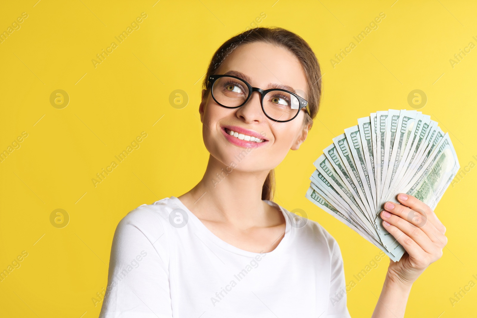 Photo of Young woman with money on yellow background