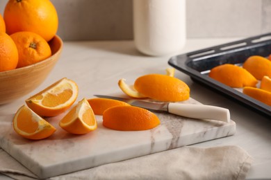 Photo of Fresh orange peels and juicy fruits on white table