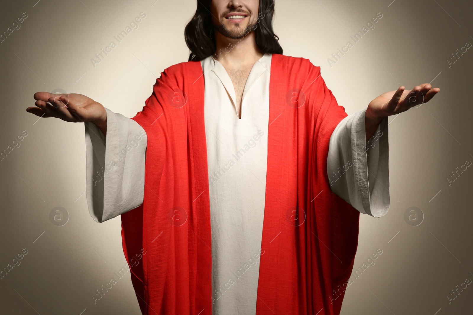 Photo of Jesus Christ with outstretched arms on beige background, closeup