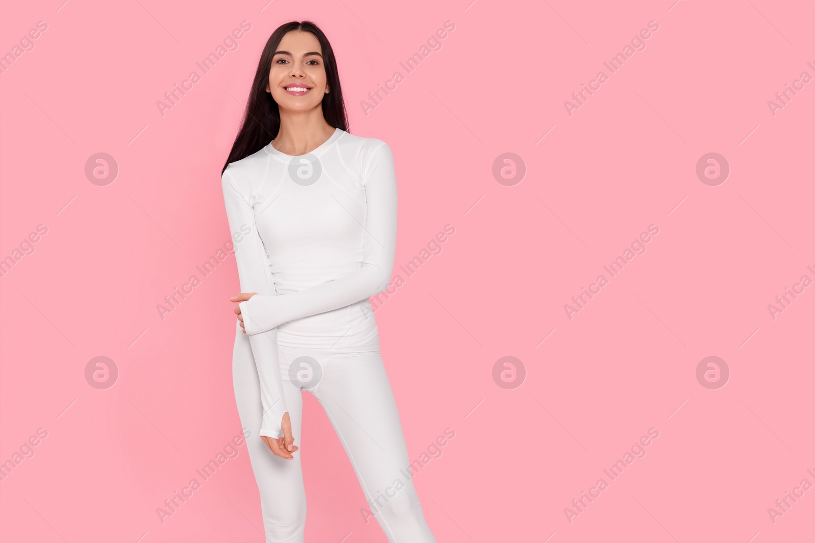 Photo of Woman in warm thermal underwear on pink background. Space for text